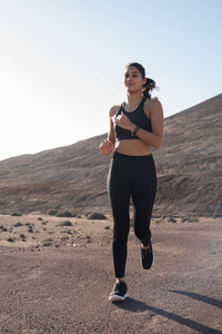 女子短跑与她身后的山上的暗石沙路