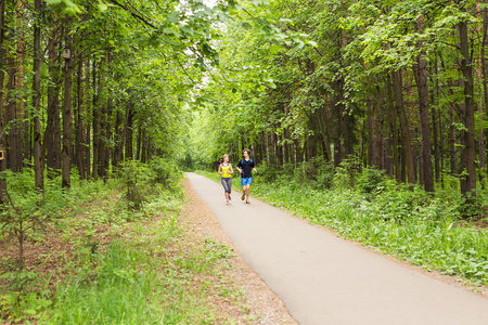 年轻的夫妇在树木繁茂的森林地区健身健康的生活方式概念的运行