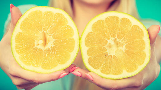女性黄色葡萄柚柑橘甫一手特写。女人营养师推荐饮食健康营养