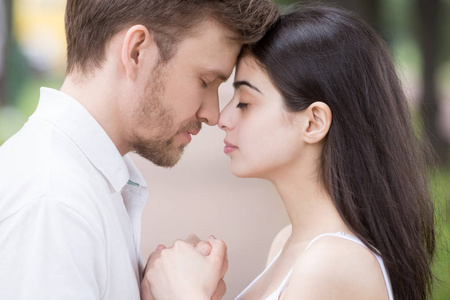 亲密接触的感性情侣牵手触摸鼻子照片