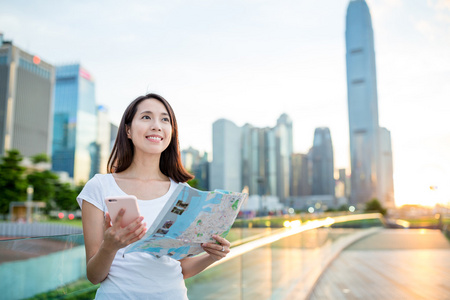 使用城市地图和手机的女人图片