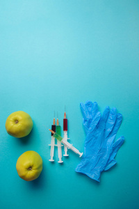 在食物或转基因的水果概念的化学添加剂。化学品的针筒的青苹果。蓝色背景上孤立