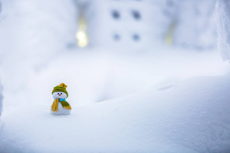 一个小小的雪人朋友站在白皑皑的雪帽和它背后是有趣雪覆盖纹理的窗口与六个正方形