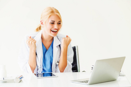 快乐成功的女医生在医院或医疗机构工作时感觉很愉快, 在办公桌上做医疗报告。成功理念