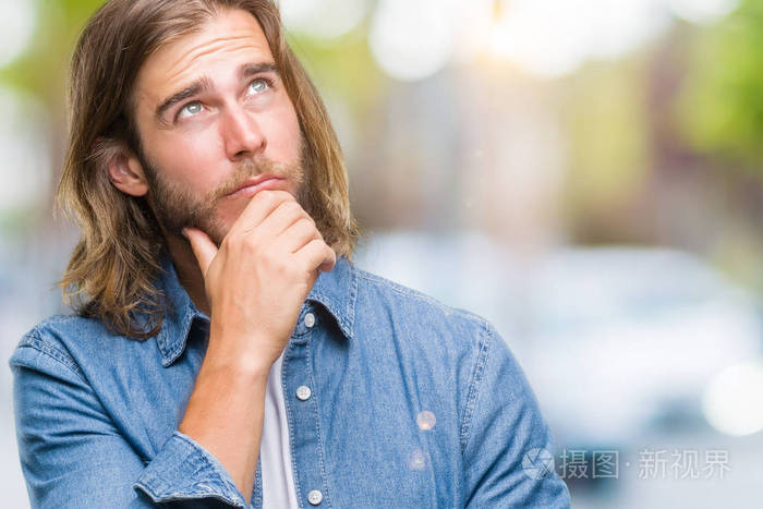 年轻英俊的男人用长发越过孤立的背景, 用手在下巴思考问题, 沉思着