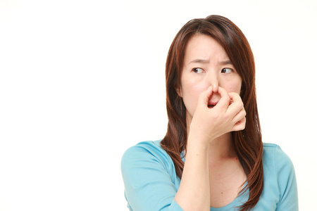 由于难闻的气味捏着她的鼻子的中年日本女子照片