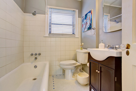 灰色古色古香的带白色浴缸和深褐色小屋的优雅浴室