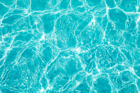 在与太阳反射的游泳池里的水波纹照片