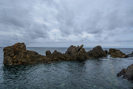 在西班牙巴斯克国家, 一组岩石在乌云密布的天空下出现在大西洋上空。