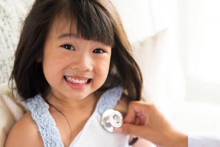 医生用听诊器检查一个小女孩。医疗保健理念