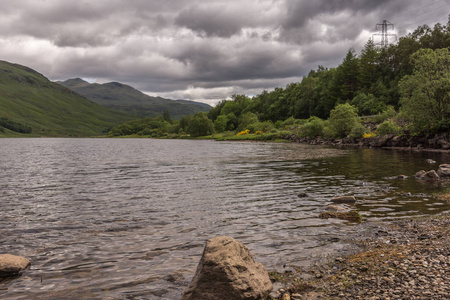 Orchy, 苏格兰, 英国的桥梁2012年6月12日 Tulla 褐色的湖在一个沉重的 cloudscape 之下被绿色的