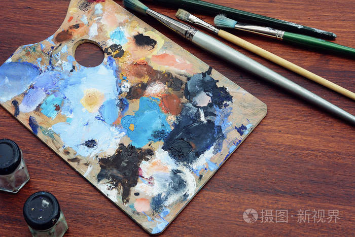 艺术家的调色板与彩色油画笔触和画笔的木质背景.艺术理念