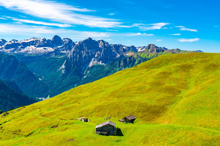 夏日美景的意大利白云岩在晴朗的天与蓝色的天空和小木屋在绿色的山丘上