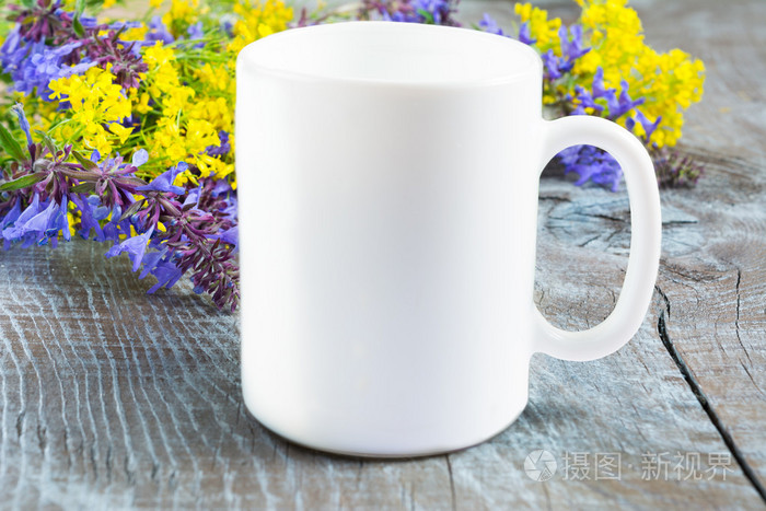 白咖啡杯子样机与淡紫色和黄色的花