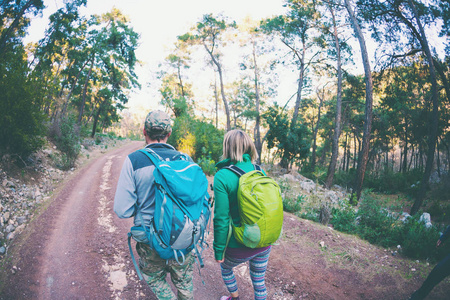 一个女人和一个男人在公园里散步.一对夫妇带着背包旅行到美丽的地方.