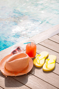 干净的玻璃杯，水瓜冰沙饮料的太阳镜 草帽和游泳池假日热带概念边界上拖鞋