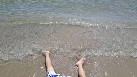 男孩在沙滩上玩耍的腿