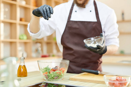 在现代餐厅厨房, 复制空间, 现代专业厨师的特写镜头与手套的手腌制绿色沙拉