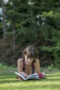 成年女性阅读的草地上铺设