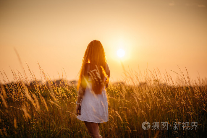 年轻漂亮的红发女孩，在日落时的现场