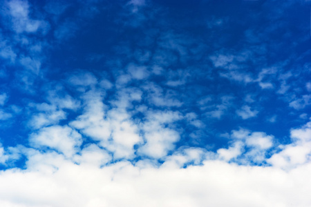 水平的底部对齐在蓝蓝的天空背景上的白色 cloudscape