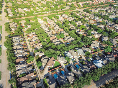 鸟瞰郊区生长在达拉斯市中心的欧文, 得克萨斯州, 美国。鸟眼绿色建筑在新细分开发紧凑的房子与车道, 广阔的邻里郊区