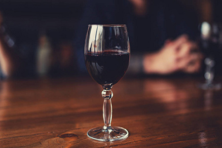 在温暖的颜色色调的照片.专注于玻璃酒.餐桌上的红酒杯特写.