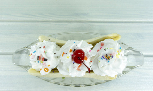 冰淇淋香蕉劈顶鞭霜道具装饰樱桃红色一玻璃被隔绝在白色木地板背景, 顶部看法