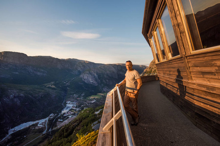 一个极端计划的肖像旅行为英俊的老人在 kjerag 的石头上的 kjeragbolten 挪威, 自拍在你的自由手中手持智能手机