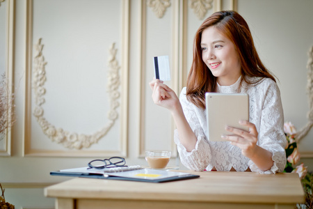 幸福的女人，在线购物，持有信用卡，使用平板电脑 c