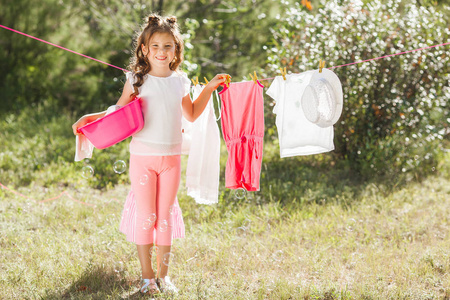 可爱的小女孩挂在户外洗衣房