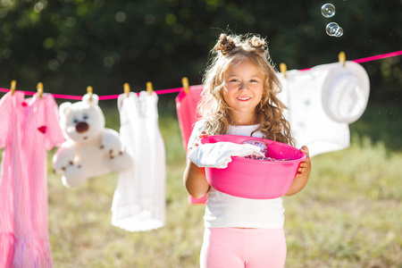 可爱的小女孩挂在户外洗衣房