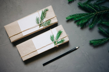 圣诞节背景与冷杉树和装饰。顶部视图与复制空间, 两个礼品盒, 铅笔, 灰色贴纸背景