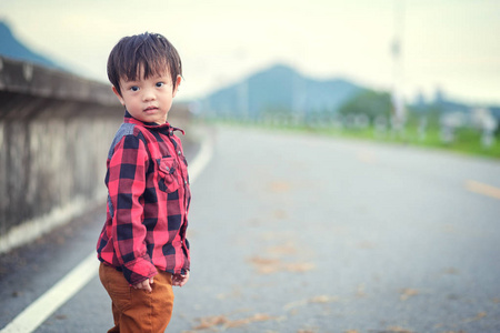 孩子们穿夹克去行驶, 站在公园里。