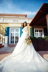 一个穿着白色婚纱的漂亮新娘正享受着在夕阳下的一座美丽拱门的篮板。良好的心情, 良好的氛围。婚礼理念