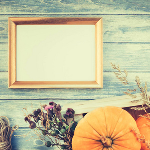 秋天橙色南瓜和干燥花的方形的上部看法与草感恩节背景蓝色色调木桌与金黄框架模仿和复制空间乡村风格, 文本模板