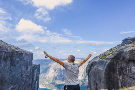 一个极端计划的肖像旅行为英俊的老人在 kjerag 的石头上的 kjeragbolten 挪威, 自拍在你的自由手中手持智能手机