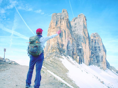 在阳光明媚的绕, 背包客在旅途中 Cime Lavaredo。观看从游览在普遍的巨型, 白云岩阿尔卑斯, 意大利