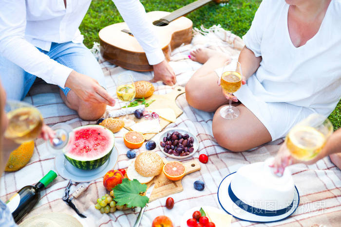 在意大利花园的绿草上的夏日野餐篮.食物和饮料概念.朋友聚会时间