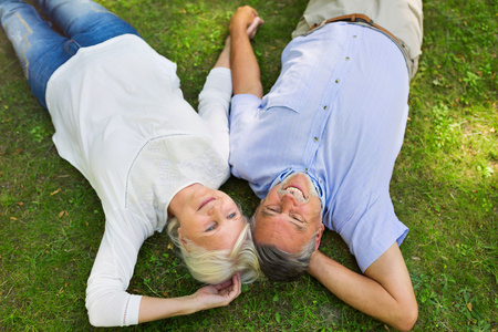 年长的夫妇躺在草地上