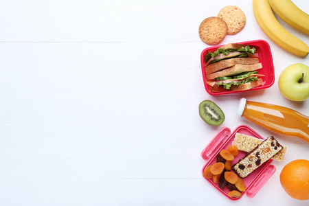 带三明治和水果的学校午餐盒在木桌上