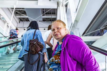 德国慕尼黑, 于2018年8月15日。人们在国际机场到达大厅的自动扶梯上走。