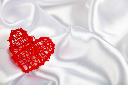 白色真丝织物, 有褶皱和红色的心。美丽的浪漫背景