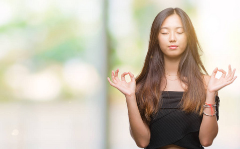 在孤立的背景下, 年轻的亚洲妇女放松和微笑闭上眼睛做冥想手势用手指。瑜伽理念