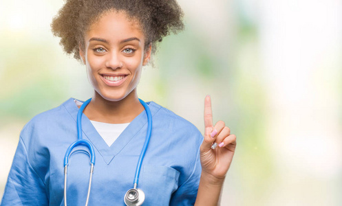 年轻的美国黑人医生妇女在孤立的背景显示, 并指出手指第一, 而微笑着自信和快乐
