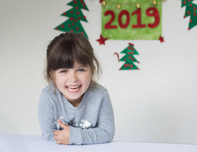 有趣的小女孩祝你在圣诞节的背景下新年快乐2019。元旦假期概念