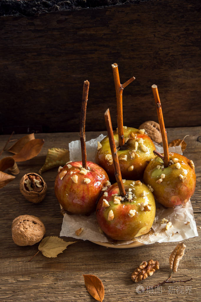 在万圣节的棍子上自制的焦糖苹果.有机小吃-核桃焦苹果