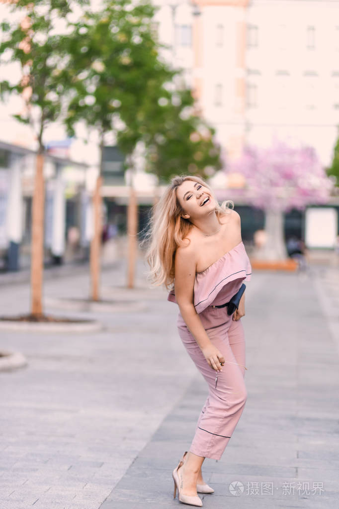 肖像美丽的年轻金发女孩在太阳镜与肿胀的嘴唇和性感的女性身体摆在