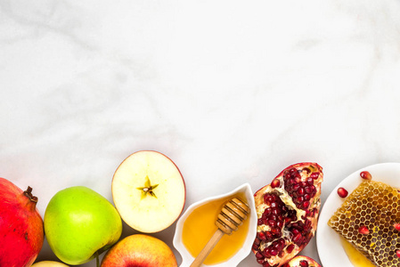 犹太假日 Rosh Hashana 背景与蜂蜜石榴和苹果在白色大理石桌。平躺。具有复制空间的顶部视图