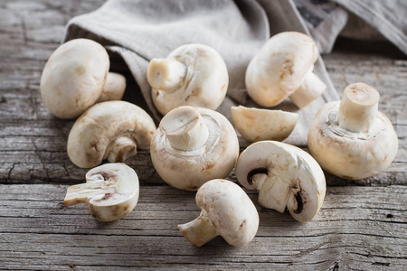 新鲜的蘑菇 champignons 在木质的背景上。秋季收获食品素食蔬菜